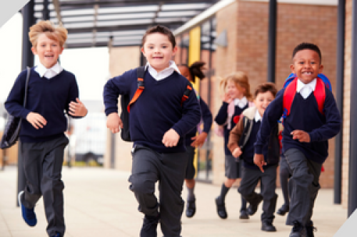Picture of children in school uniform happily running out of school